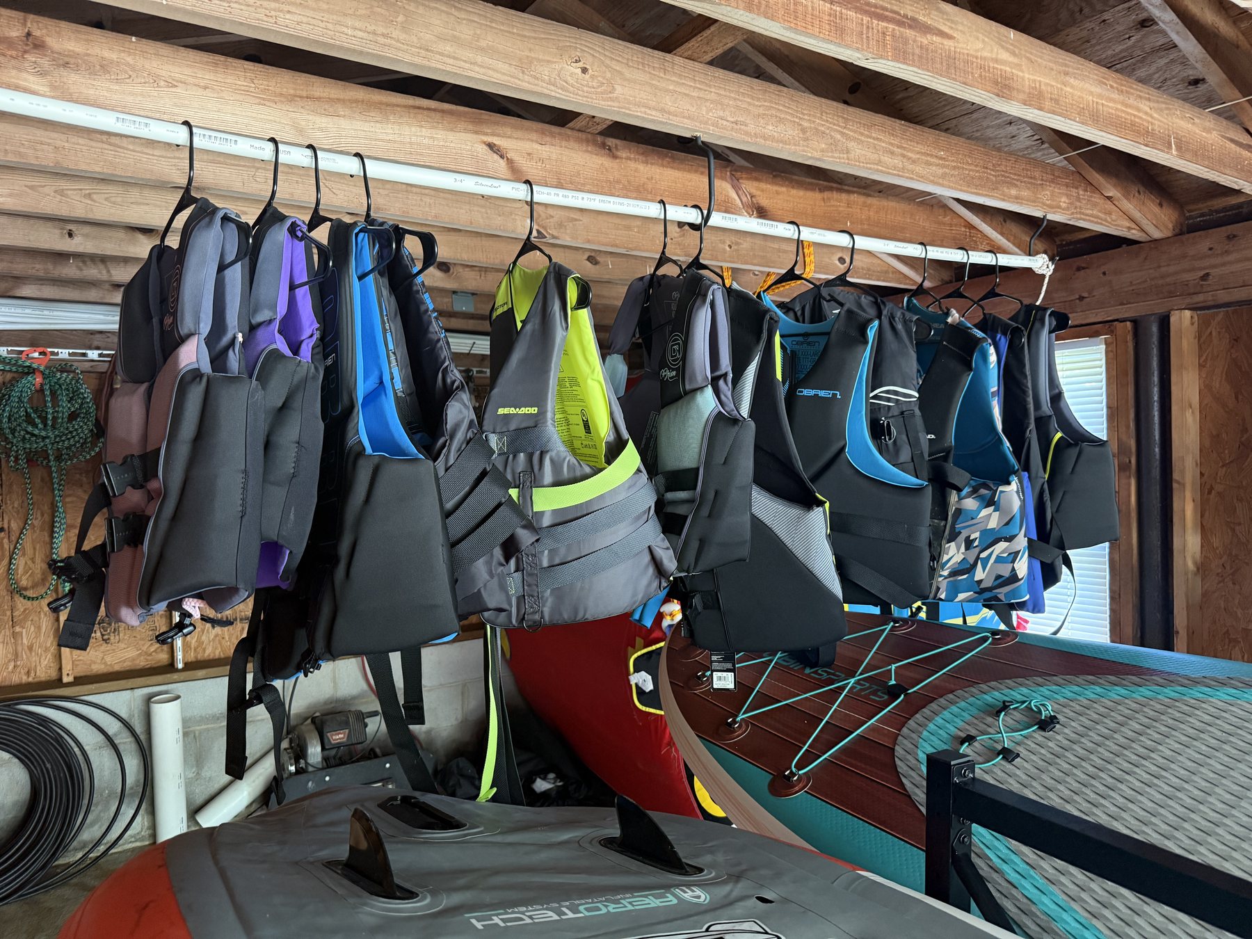 Boat house stocked with kayaks, paddle boards, life jackets, and Lake Murray water toys.