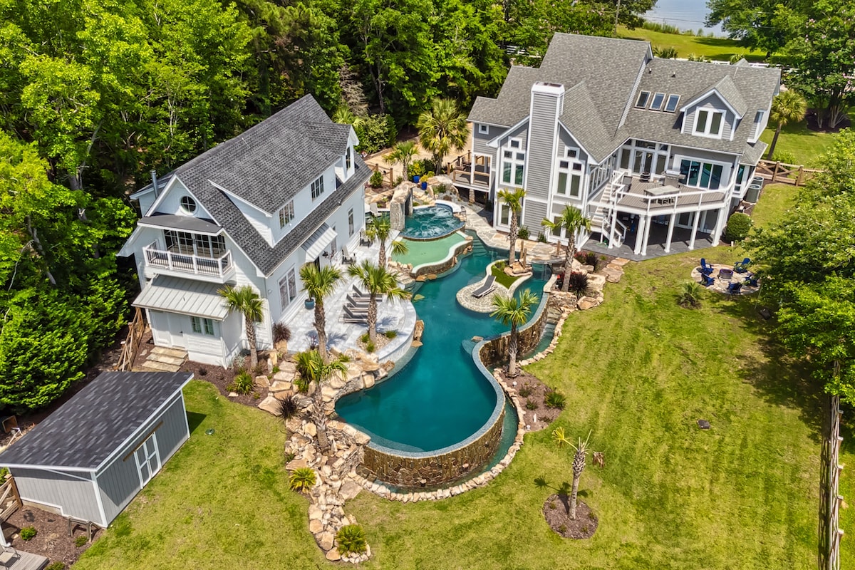 Daytime aerial view of Polaris Pointe on the Cove with pool, cottage, main house, and Lake Murray shoreline.
