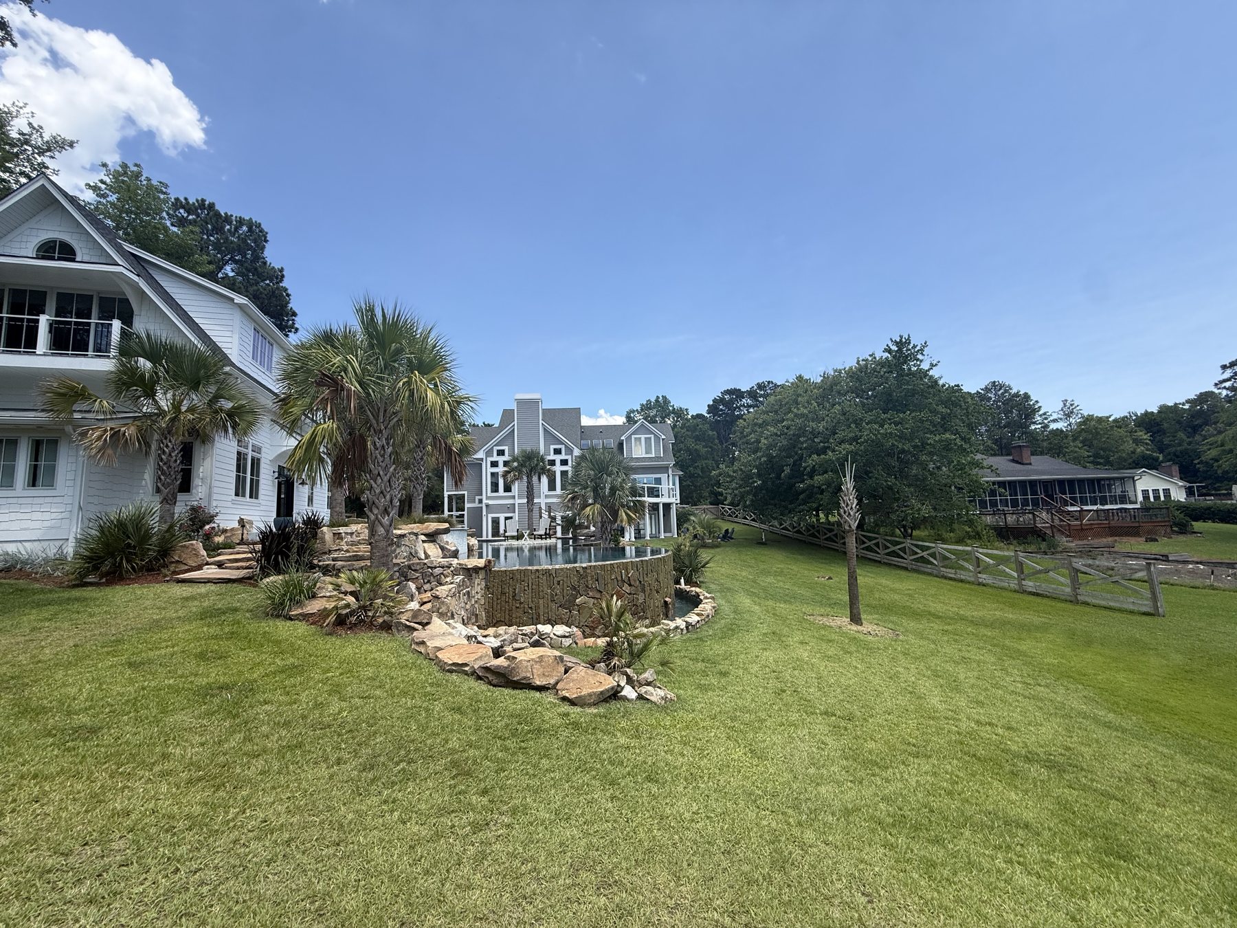 Daytime view of the estate lawn, pool area, and Lake Murray shoreline.